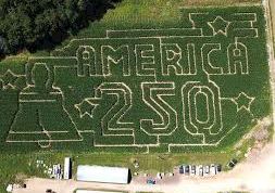 The image shows a hillside with giant chalk graffiti reading &ldquo;AMERIKIA&rdquo; and &ldquo;2?SIO,&rdquo; plus other doodles and figures.