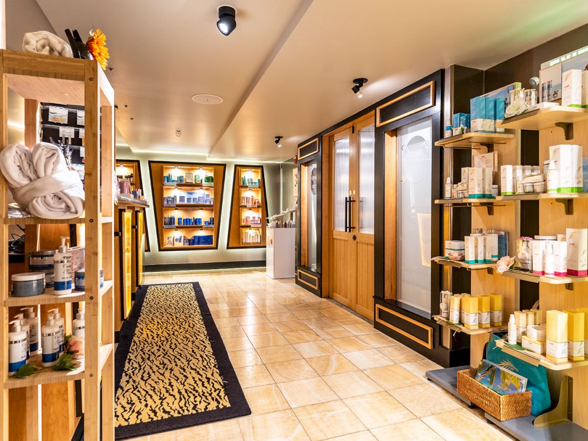 A cozy spa or wellness center reception area with shelves of products, warm lighting, and a tiled floor, inviting relaxation.