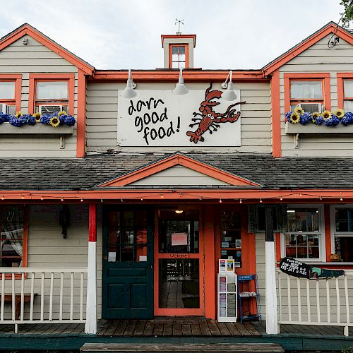 This image shows a charming restaurant with a sign reading "darn good food!" and featuring a lobster illustration. The building has flower boxes.