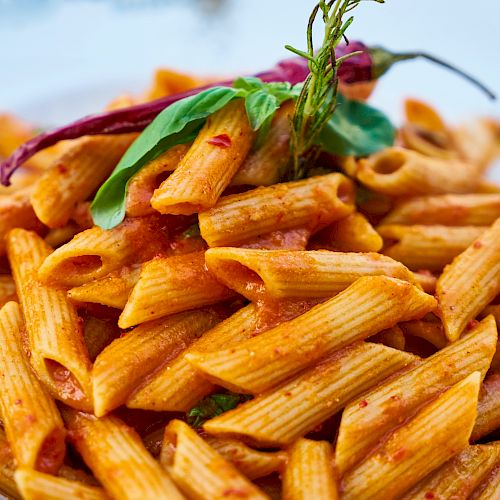 A plate of crispy, golden fries with a small herb garnish on the side, invitingly piled high.