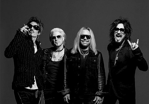 Rock band photo with four musicians posing in black outfits against a dark backdrop. Top it at 140 characters, always ending the sentence.