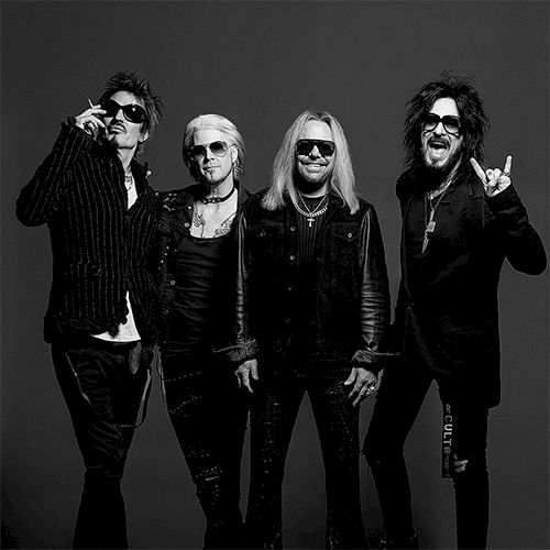 Rock band photo with four musicians posing in black outfits against a dark backdrop. Top it at 140 characters, always ending the sentence.