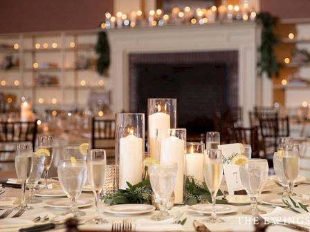 A formal dining table set for a romantic event with lit candles, champagne flutes, and elegant centerpiece in a warmly lit room ending with a festive vibe.