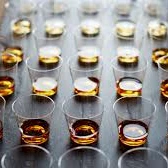 Chewable capsules arranged in a blister pack on a wooden table, with amber/orange pills visible in each slot.